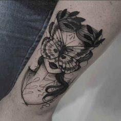 a woman's leg with a butterfly and flower tattoo on the side of her leg