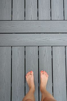 a person standing on a deck with their feet up