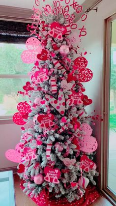 a pink and silver christmas tree with hearts on it