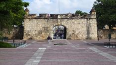 the entrance to an old castle with people walking around