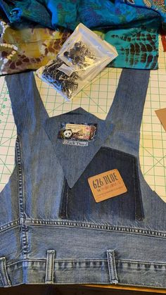 a pair of blue jean overalls sitting on top of a cutting board