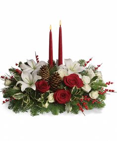 a christmas centerpiece with candles and flowers