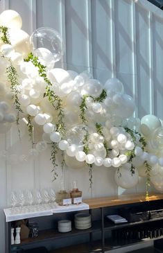 balloons and greenery are hanging from the ceiling