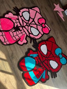 two spiderman rugs sitting on the floor in front of a wall with pink and blue designs