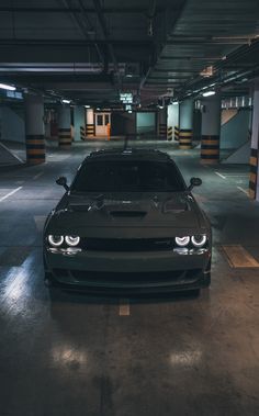 a car parked in a parking garage with lights on it's headlamps