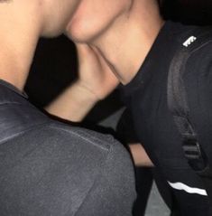 two young men are kissing each other in the dark