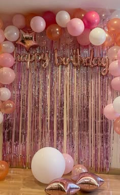 balloons and streamers are on the floor in front of a backdrop that says happy birthday