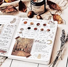 an open journal with autumn leaves and other things on it next to a jar of honey