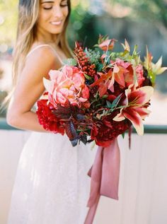 a woman holding a bouquet of flowers in her hands