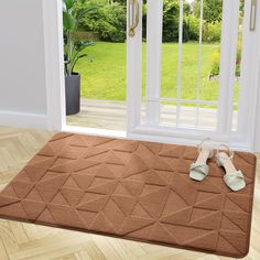 a pair of sandals sitting on top of a brown rug in front of a door