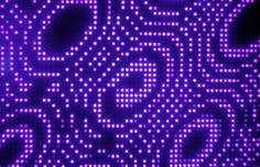 an abstract purple background with circles and dots in the shape of letters that appear to be illuminated