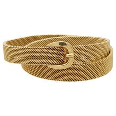 A rare vintage Hermès belt buckle wrap bracelet set in solid 18k yellow gold. The bracelet has been beautifully handcrafted in yellow gold and predominately features the iconic Hermès belt buckle motif which acts as the clasp of the bracelet. The main body of the piece is composed of articulated woven gold which has a stunning beaded textured to it. It is designed to wrap around the wearers wrist with ease. The bracelet has a lovely weight and lies comfortably on the wrist. The clasp is a secure Adjustable Gold Bracelets With Gold-tone Hardware, Yellow Gold Bracelets With Gold-tone Hardware As Gift, Yellow Gold Bracelet With Gold-tone Hardware As Gift, Elegant Adjustable Bracelet With Gold-tone Hardware, Elegant Adjustable Bracelets With Gold-tone Hardware, Classic Gold Bracelets With Gold-tone Hardware, Classic Gold Bracelet With Gold-tone Hardware, Gold Belts For Formal Occasions, Gold Double Band Bracelets For Formal Occasions