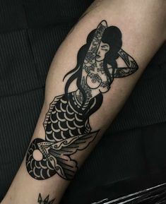 a black and white photo of a woman with a fish tattoo on her arm,