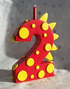 a red and yellow wooden number two with polka dot dots on it's sides