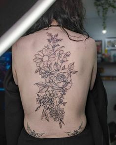 the back of a woman's body with flowers on her upper and lower back