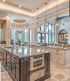 a large kitchen with marble counter tops and an island in front of the stove top oven