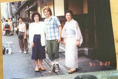 an old photo of people standing on the street