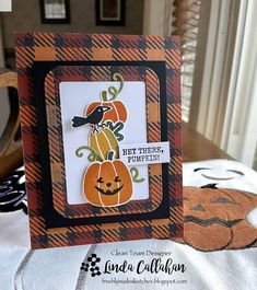 a close up of a card on a table with pumpkins and other decorations in the background