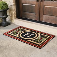 a door mat that has the letter h on it in front of a brown door