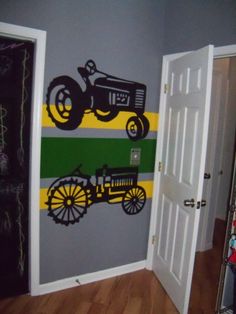 a room with a tractor painted on the wall next to an open door that leads to another room