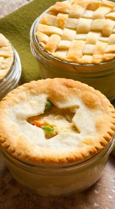 three small pies sitting on top of a green napkin next to each other in glass jars