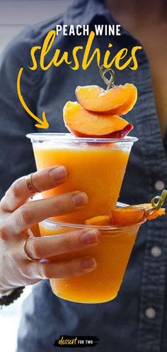 a woman holding a glass with peach wine slushies in it and the words peach wine slushies above it