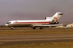 a red and white airplane is on the runway