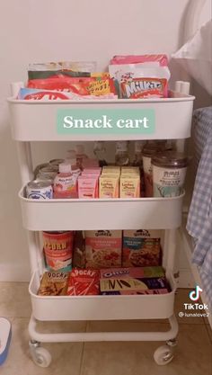 a snack cart with snacks on it next to a bed