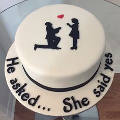 a white cake with black writing on it that says, he asked she said yes