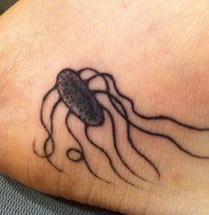 a black and white photo of a jellyfish on someone's foot with ink