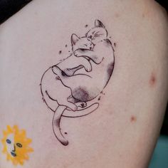 a cat tattoo on the back of a woman's shoulder