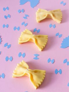 three small pieces of yellow cake sitting on top of a pink surface with blue polka dots