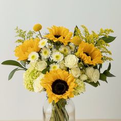 a vase filled with yellow and white flowers