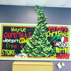 a christmas tree made out of books in front of a bulletin board