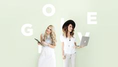 two beautiful young women standing next to each other with laptops on their lap tops