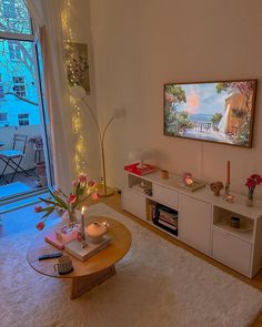 a living room filled with furniture and a flat screen tv mounted to the side of a wall