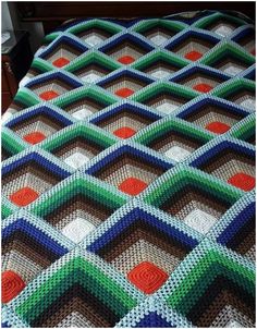 a crocheted blanket that is on top of a bed