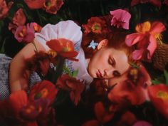 a woman laying in flowers with her eyes closed