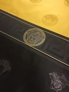 two black and gold scarves sitting on top of a table next to each other