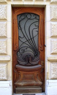 an ornate wooden door with glass on it