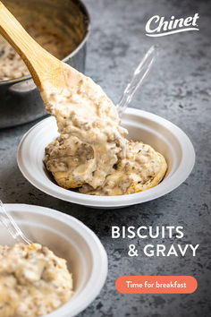 a spoon full of biscuits and gravy on top of two small white plates