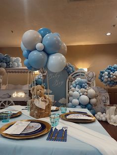 blue and white balloons are on display at a baby's first birthday party table