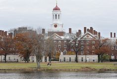 a large building with a clock tower next to a body of water