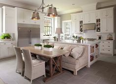 a kitchen with white cabinets and an island in the middle, surrounded by gray tile flooring