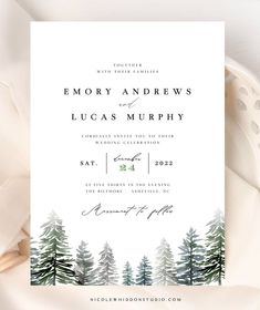 an image of a wedding card with pine trees on the front and bottom, in white paper