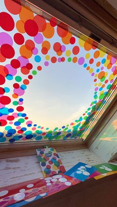 the inside of a building with colorful balloons hanging from it's ceiling and an open window