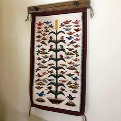 the wall hanging is decorated with birds and flowers on it's side, along with two hooks