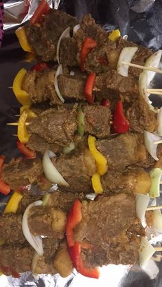 several skewers of meat and vegetables on tin foil