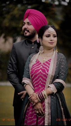 a man in a turban and woman in a pink dress standing next to each other