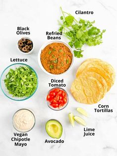 the ingredients to make guacamole laid out on a white marble counter top